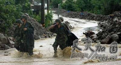 图为救援官兵冒雨参与抗洪抢险。