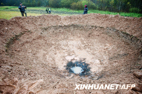 10月26日,在拉脱维亚一个北部城镇,人们在“疑似”陨石坑旁走动。近日,一个“疑似”陨石在拉脱维亚北部一城镇旁坠落,砸出一个直径约为15米的陨石坑。