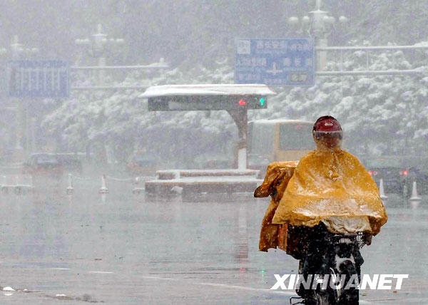 11月1日,一位市民冒雪在北京长安街上骑行。