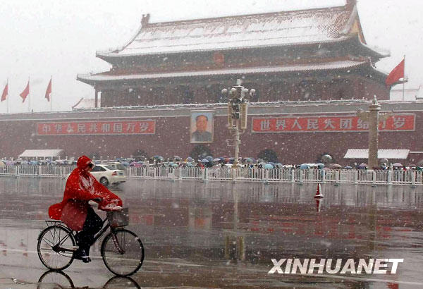 11月1日,一位市民冒雪在北京天安门前骑行。