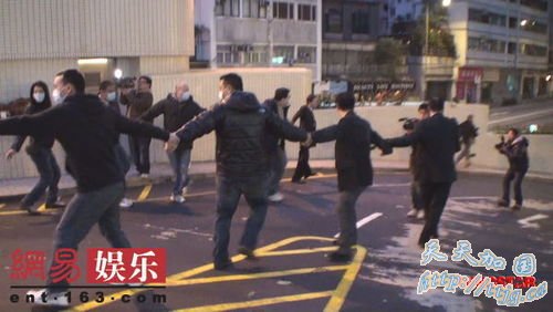 数十名保安手拖手护送赌王何鸿燊出院。