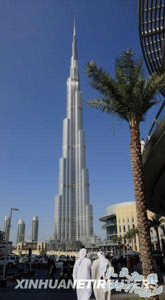 1月3日,人们走过位于阿拉伯联合酋长国迪拜的“迪拜塔”。总高超过800米、楼体160层的“迪拜塔”定于2010年1月4日举行竣工典礼。