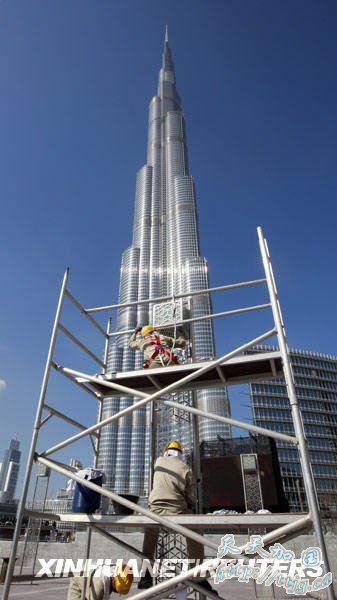 1月3日,工人在阿拉伯联合酋长国迪拜的“迪拜塔”附近工作。总高超过800米、楼体160层的“迪拜塔”定于1月4日举行竣工典礼。