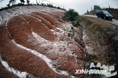 1月5日,湖南岳阳境内一条公路的护坡出现轻度覆冰积雪。