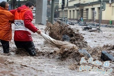 2月20日在葡萄牙马德拉岛首府丰沙尔,救援人员帮助一名男子穿过被洪水淹没的街道