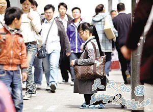 女子挎名牌包闹市跪地乞讨 称只为三元或路费