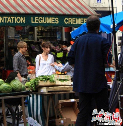 法国第一夫人卡拉·布鲁尼(图右穿白衣者)与男演员欧文·威尔森听导演说戏。 法国第一夫人卡拉·布鲁尼(图右穿白衣者)与男演员欧文·威尔森听导演说戏。