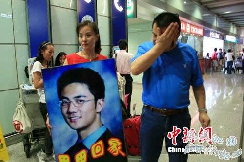 翟田田更衣间隙,其父拭去脸上的泪水。