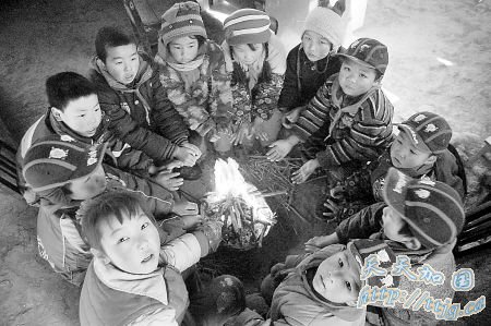 教室里异常寒冷,孩子们围坐在火盆前取暖。